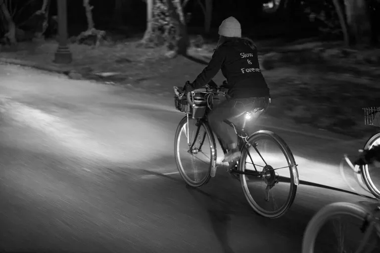 Black and white image of Kat riding on her Trek in the dark.