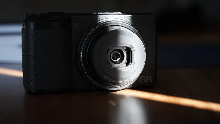 The front of a Ricoh GR III with a sliver of sunlight over its front lens element