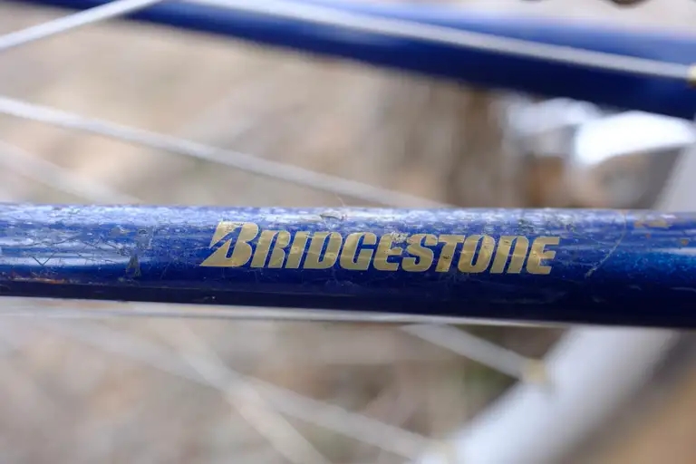 A close-up of the gold Bridgestone decal on the chainstay.