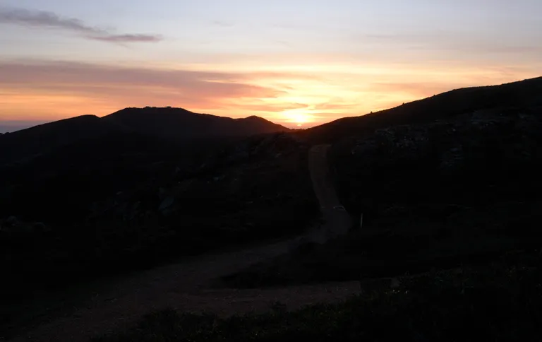 The last fraction of the sun going under the horizon behind the trails