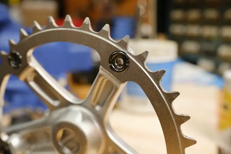 The 38T chainring mounted on the crank spider from the back showing the edge of the crank spider sticking above the valley of the chainring teeth.