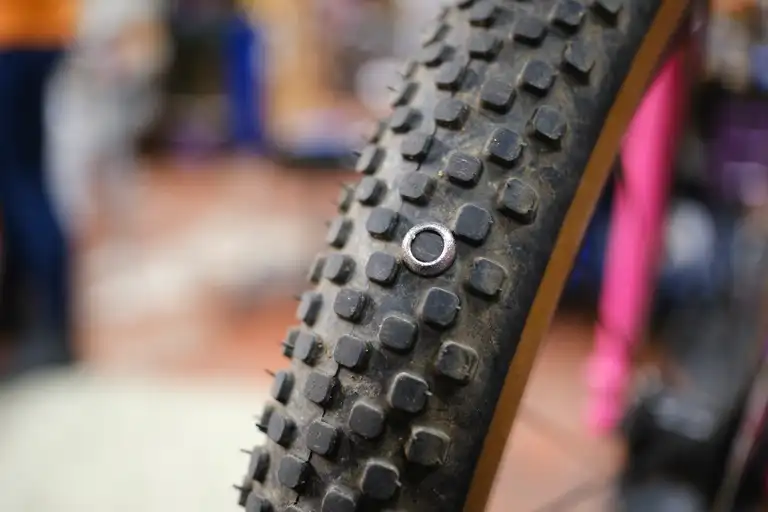 A silver washer around a tire knob on a Rene Herse knobby tire.