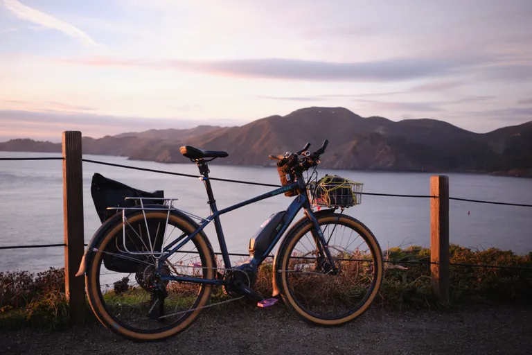 My Kona Dew-E e-bike in the golden hour light in front of the ocean and the Marin Headlands