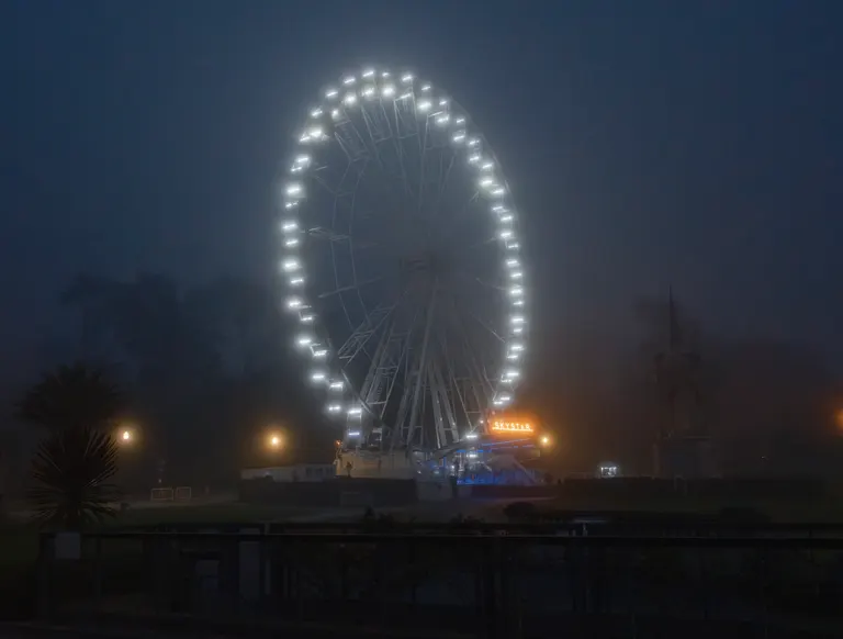 The Skystar ferris wheel glowing in the fog.