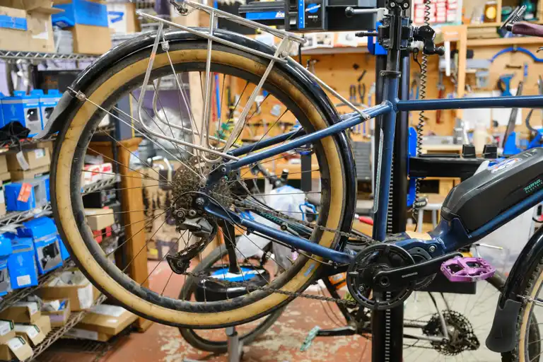The rear of a blue bike showing a black fender being setup