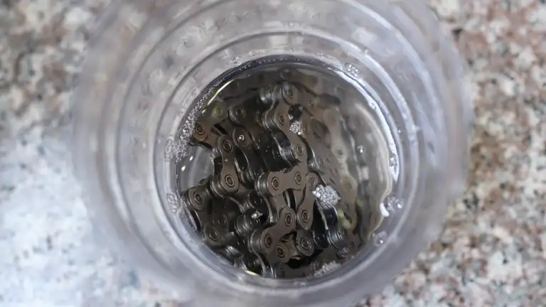 A bunched up chain in an empty bottle filled with Silca chain stripper