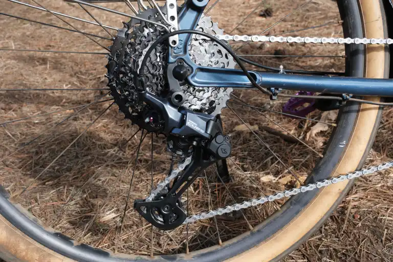 A section of the rear triangle of a blue e-bike showing the new CUES cassette and derailleur mounted up.